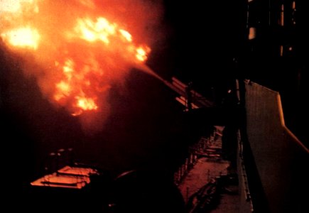 USS Newport News (CA-148) firing on targets in Vietnam at night, circa in 1967