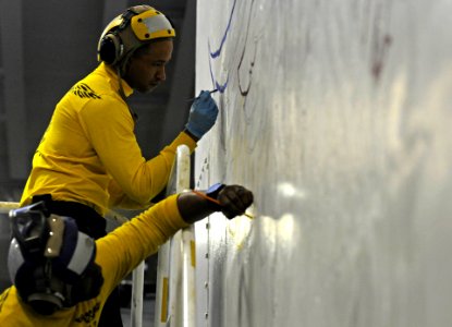 USS Peleliu aviation boatswain's mates paint wings 140427-N-AQ172-008