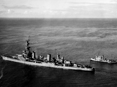 USS Pensacola (CA-24) at sea with tugs on 14 October 1943 (19-N-67932)