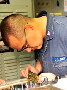 USS Rusmore sailor replaces circuit card 120225-N-YQ852-009