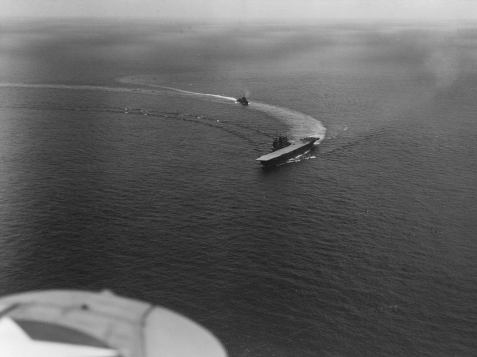 USS Saratoga (CV-3) at sea with a destroyer following in her wake c1942