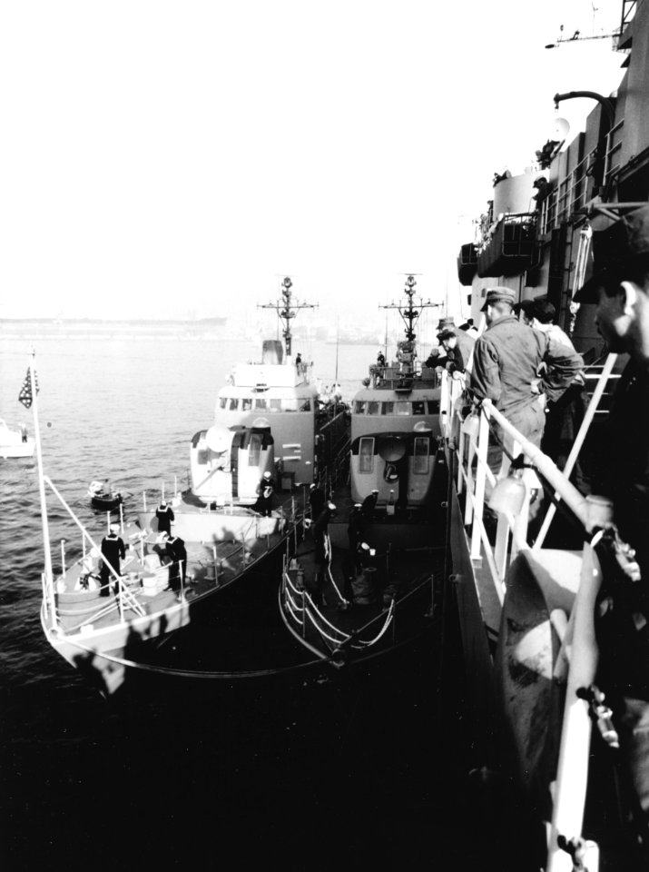 USS Surprise (PG-97) and USS Defiance (PG-95) tied up to USS Austin (LPD-4) c1971