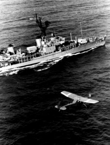 USS Theodore E. Chandler (DD-717) undeway off the coast of Vietnam with a Cessna O-1 Bird Dog flying alongside, 20 November 1966 (USN 1119104)