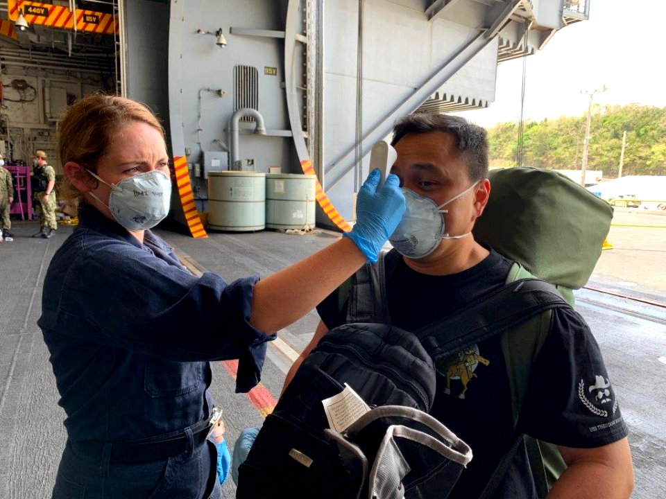 USS Theodore Roosevelt (CVN-71) Dental Tech (HM2 Yost) performing temperature screening for Dental Department Chief (Chief Aquino) as he returns from Quarantine in Guam (49870596336)