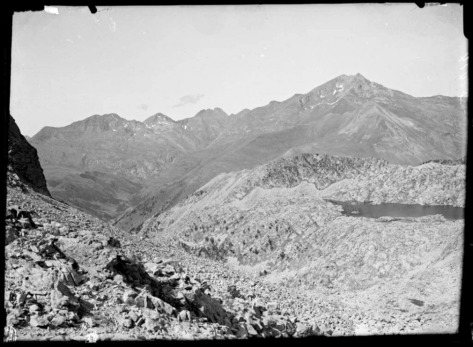Vall rocosa amb un llac i muntanyes al fons