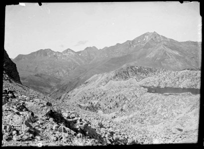 Vall rocosa amb un llac i muntanyes al fons