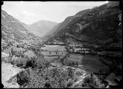 Vall de la ribera de Gistaín amb algunes cases i conreus voltats d'arbres i vegetació
