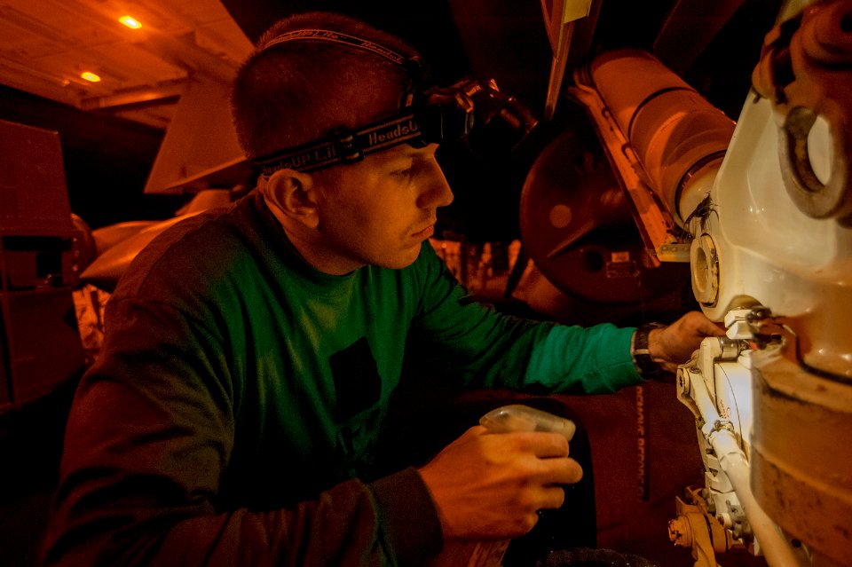 VAQ-139 Sailor cleans the nose landing gear of an EA-18G Growler 141104-N-TP834-082