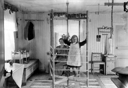 Varpning. En flicka klättrar på varpställningen - Nordiska museet - NMA.0029057