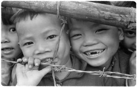 Vietnam....Vietnamese children of the Phong Dien refugee hamlet peer through a fence. There are 126 families, 10... - NARA - 532507
