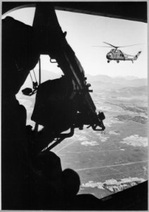 Vietnam, helicopter and soldier approaching target. Viet Nam Photo Service., ca. 1965 - NARA - 541977