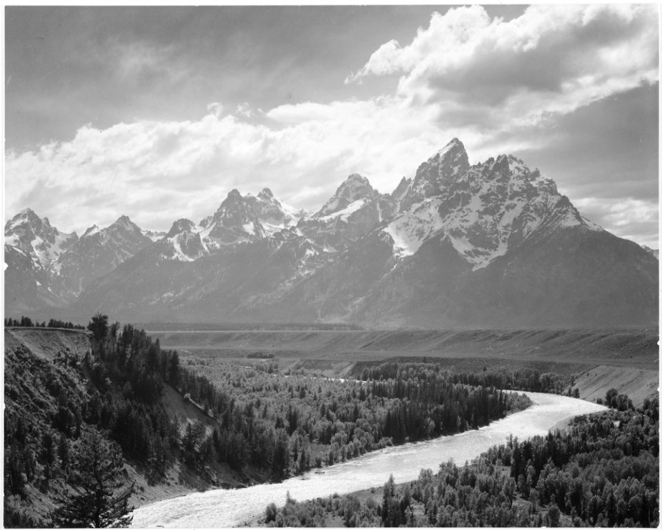 View from river valley towards snow covered mountains, river in foreground from left to right, Grand Teton National Pa - NARA - 519905