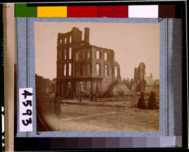 View in the Burnt District, Richmond, Va., showing two women dressed in black approaching shell of four-story building, gutted by fire LCCN96510306