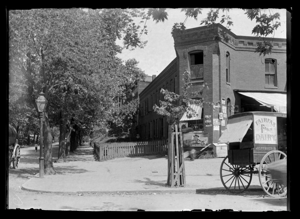 View of 21st Street, N.W., East side, looking North from E Street with a dairy cart sitting at the curb in front of a corner shop LCCN2016646864