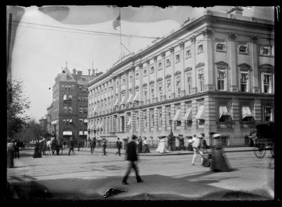 View of E Street, N.W., North side, looking West from 7th Street showing passersby walking along the street and the old General Post Office on the corner and the U.S. Civil Service LCCN2016646823