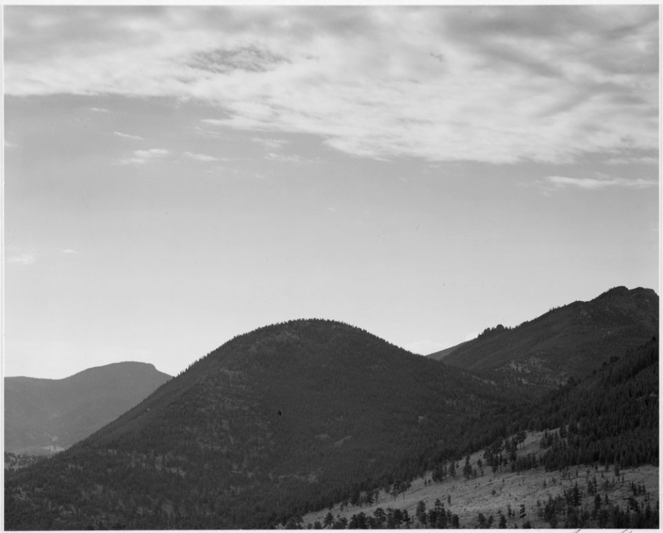 View of hill with trees, clouded sky, In Rocky Mountain National Park, Colorado, 1933 - 1942 - NARA - 519958