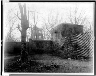 View of stable at the Octagon House, Washington, D.C. with brick fence, trellis fence, and tree LCCN91787313
