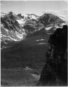 View of snow-capped mountain timbered area below, In Rocky Mountain National Park, Colorado. (Vertical Orientation), 1 - NARA - 519959