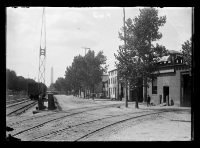 View of Virginia Avenue at 6th Street, S.W., showing street and railroad tracks in the foreground near the Adams Express Co. and the Washington Monument in the distance LCCN2016647123