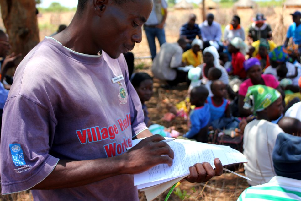 Village Health Worker Checks Health Records, Zimbabwe (36273605994)