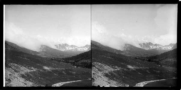 Vista d'una vall amb un riu i muntanyes al fons photo