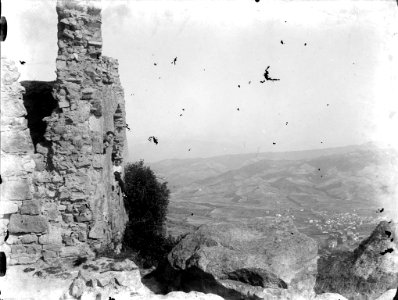 Vista d'un poble des d'unes ruïnes dalt a la muntanya amb un grup de gent (AFCEC RIBASV C 2611)
