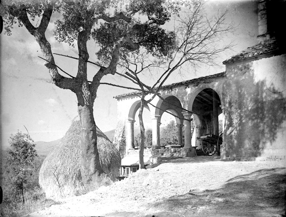 Vista d'una masia amb una arbre, una pila de palla i un carro (AFCEC RIBASV C 2740)