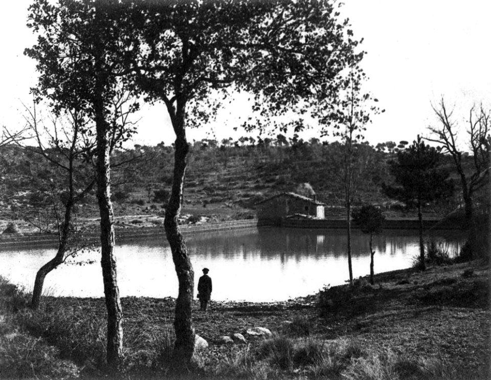 Vista general del Molí de Lladó amb bassa i un nen en primer terme