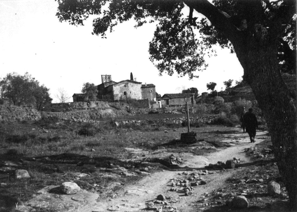Vista general del Pujol de Planès amb dos homes al camí