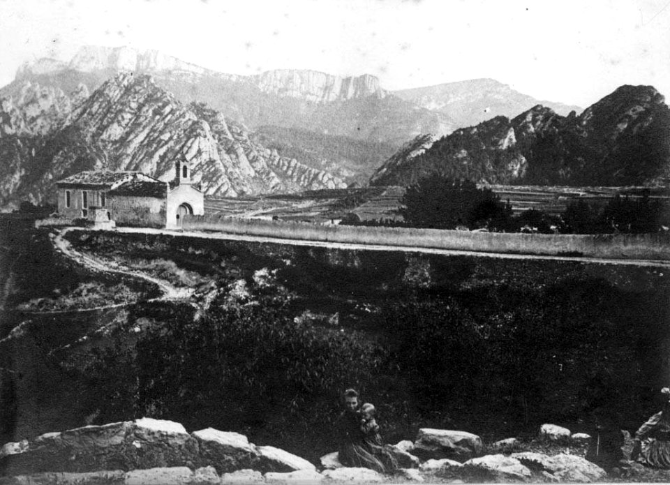Vista llunyana de la Capella de la Pietat de Sant Llorenç de Morunys i les muntanyes al fons (AFCEC EMC X 6576)