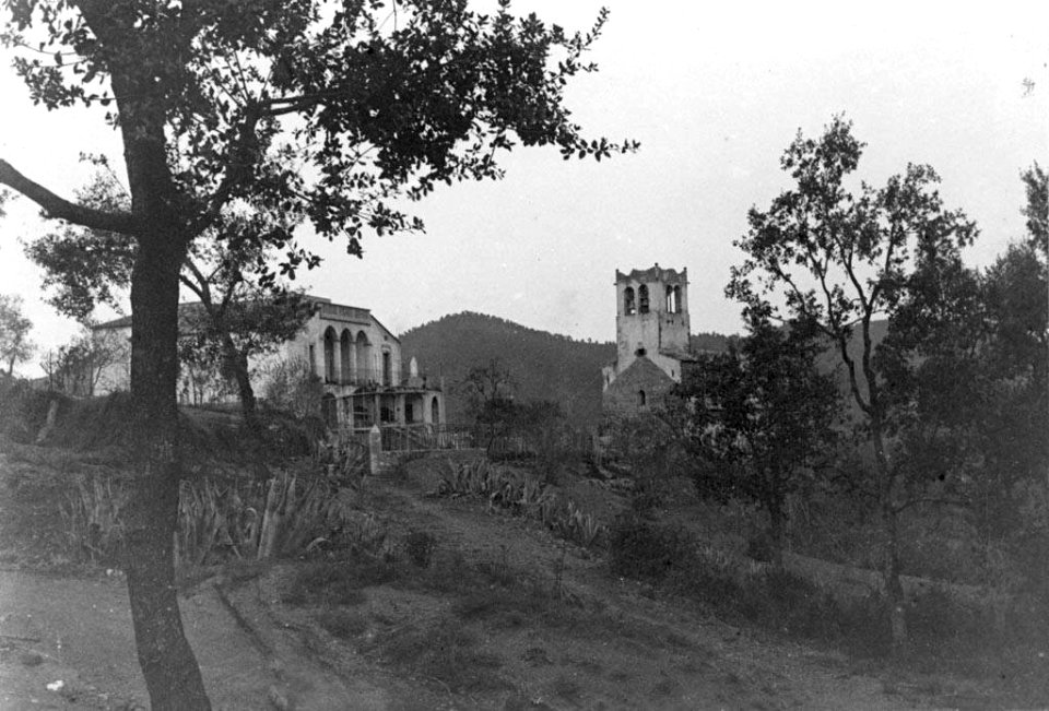 Vista parcial d'una masia i l'església de Sant Llorenç d'Adri
