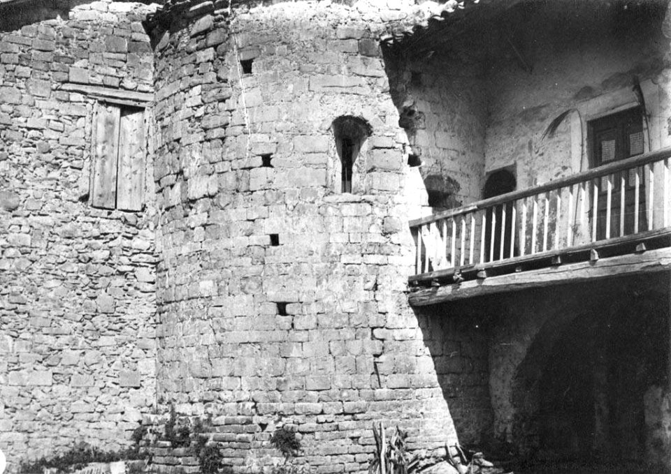 Vista parcial d'una paret de l'Església romànica de La Nou i una casa