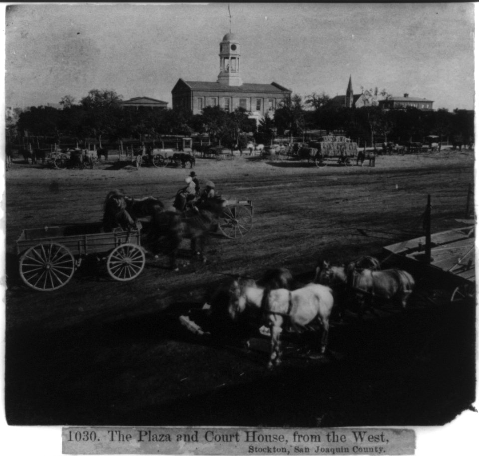 Wagon teams parked on the Plaza with Court House in background, from the West, Stockton, San Joaquin Co. LCCN2002719814