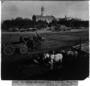 Wagon teams parked on the Plaza with Court House in background, from the West, Stockton, San Joaquin Co. LCCN2002719814