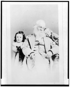 Walt Whitman, three-quarter length portrait, seated, facing slightly right, with Kitty (Katherine D.) Johnston and Harry (Harold Hugh) Johnston, children of John H. and Amelia Johnston LCCN96500740