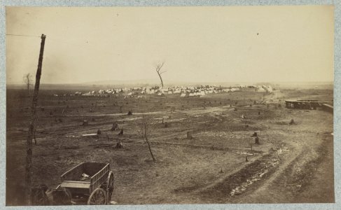 Wagon parked near a telegraph pole in foreground with a camp in the background LCCN2012648030 photo