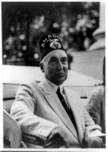 Warren G. Harding, half-length portrait, seated in vehicle, facing right, wearing mason's hat LCCN89708456