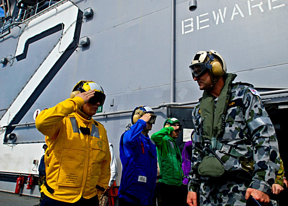 Warrant Office of the Royal Australian Navy Mark Tandy being saluted by USS Essex (LHD-2) sailors during visit 090720-N-9950J-118