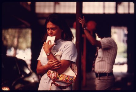 Student Nurse Stands Deep in Thought Waiting for Her Car to Complete Testing at an Auto Emission Inspection Station in Downtown Cincinnati, Ohio...09-1975 (4266538878)