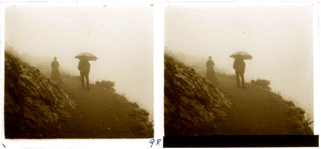 Un home i una dona caminant sota la pluja per un camí de muntanya