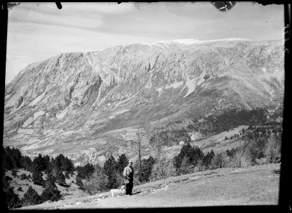 Un home i un gos al coll de Ratés i al fons el Turbón amb neu photo