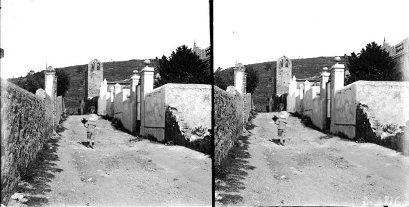 Un nen en un carrer amb l'església de la Mare de Déu del Coll al fons