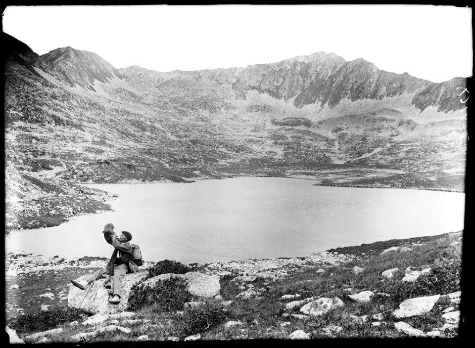 Un home assegut vora l'estany superior de Rosari