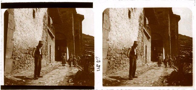 Un senyor i un grup de nens al carrer al costat d'una casa