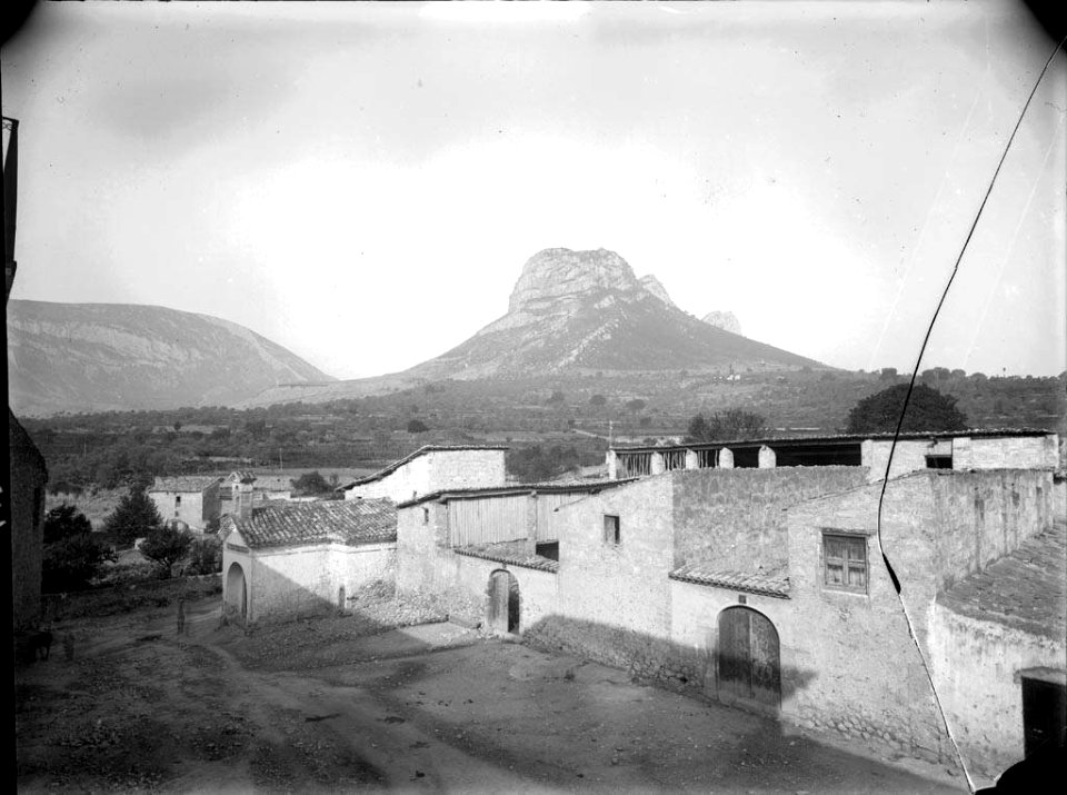 Un carrer d'Organyà amb la serra de Santa Fe al fons