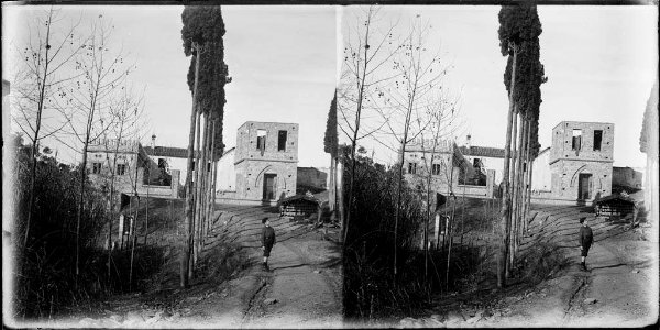 Un nen en un camí voltat de xiprers i al fons cases de Sant Medir