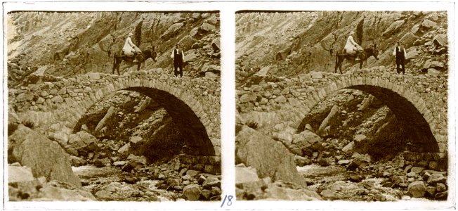 Un home i una dona muntada en un ase passant el pont de Cremal