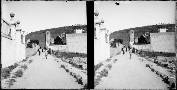 Un nen i més gent en un carrer amb l'església de la Mare de Déu del Coll al fons