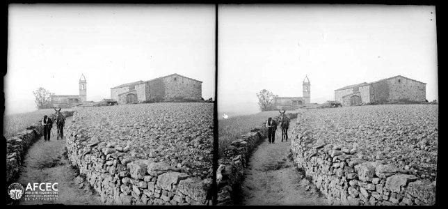 Un home amb un ruc en un camí i al fons el nucli de Linya amb l'església de Sant Andreu