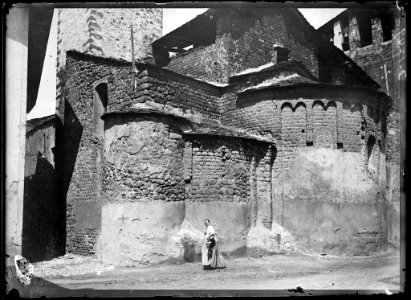 Una dona davant l'absis de l'església de Sant Miquel de la Seu d'Urgell (AFCEC SOLER D 1249)